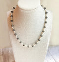 Necklace with alternating black and white beads on a mannequin bust.