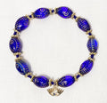 Blue beaded bracelet with gold accents on a white background