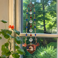 Handmade America 250 commemorative suncatcher featuring a Bald Eagle, American flag heart pendant, crystal prisms, and patriotic red, white, and blue accents hanging in a window.