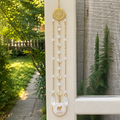 Handmade Aries zodiac suncatcher featuring a Milky Quartz pendant, faceted crystal beads, and gold-tone accents hanging in a sunlit window.