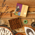 A box of Phool Lavender Incense Cones displayed on a wooden surface, with the brand name 'TOH' visible on the packaging. The cones are arranged in a rectangular pattern inside the box, and there are lavender flowers and incense accessories around the box.