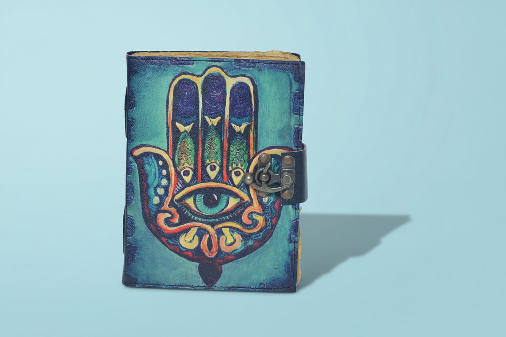 Colorful Hamsa hand design on a leather-bound notebook with metal clasp.