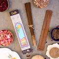 A pack of Phool Oudh Incense Sticks displayed alongside temple flowers, resinous substances, and other incense accessories on a table.