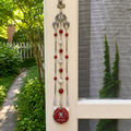 Handmade Scorpio zodiac suncatcher featuring a Red Jasper pendant, crystal prisms, and silver angel wing accents hanging in a sunlit window.