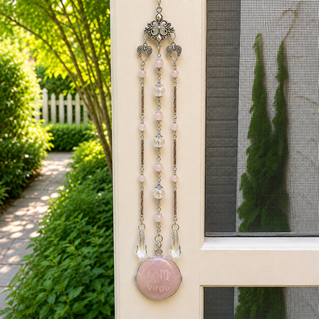 Handmade Virgo zodiac suncatcher featuring a Rose Quartz pendant, crystal prisms, and silver angel wing accents hanging in a sunlit window.