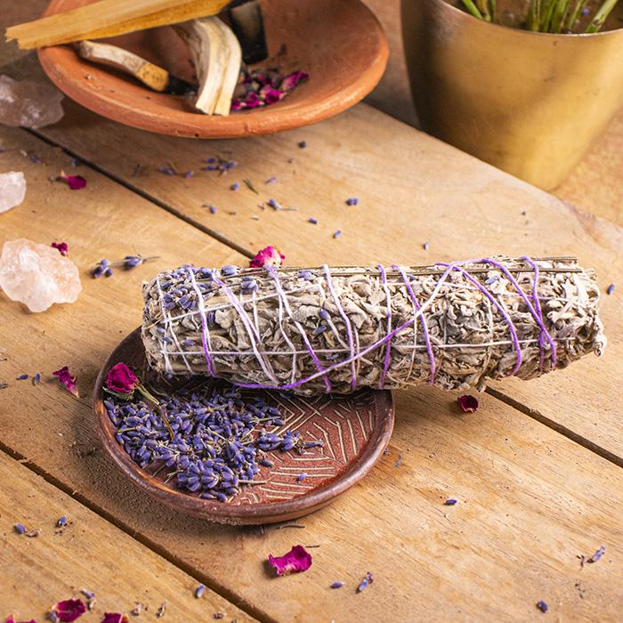 Sage bundle on a wooden surface with lavender and crystals