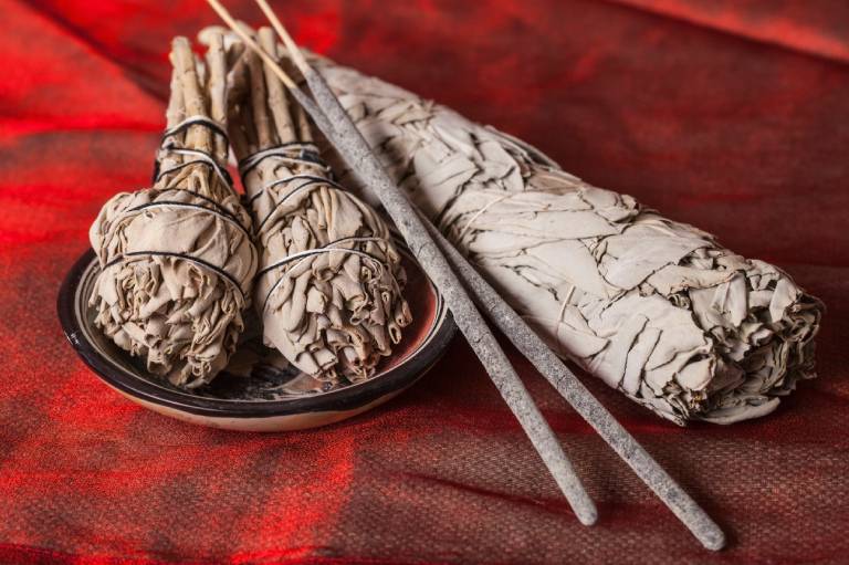 White sage smudge sticks on a red fabric background